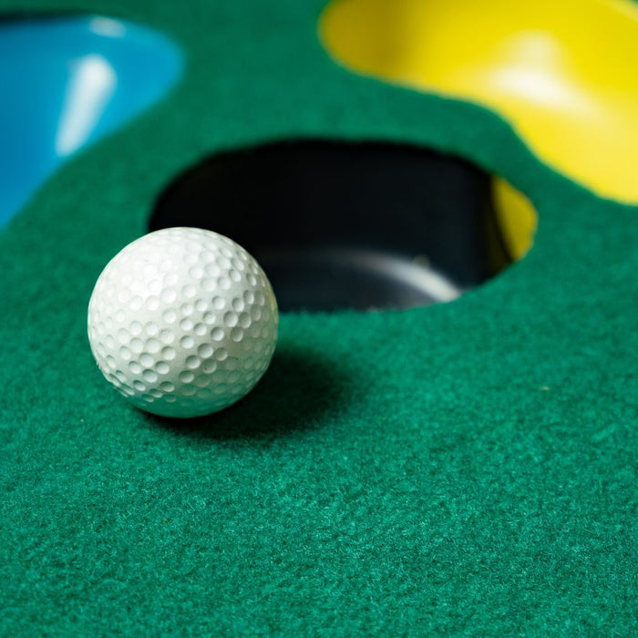 putting mat with golf ball and various holes