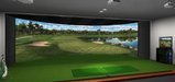Golf simulator setup with a large screen displaying a golf course using the Auto Tee Up System.