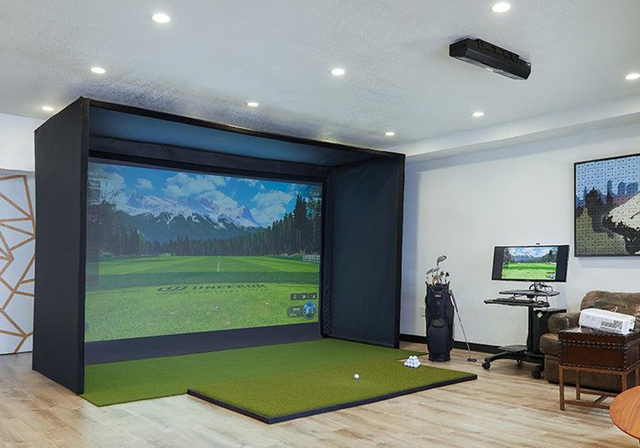 Indoor golf simulator setup in a room with a screen displaying a golf course using Carl's Place Premium Enclosure.