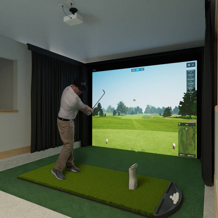 Person playing golf simulation game in a home setting with a screen displaying a golf course using Carl's Place Premium Enclosure.