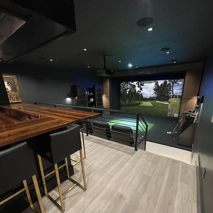 Indoor recreational room with a bar area and golf simulator using Carl's Place Premium Enclosure.